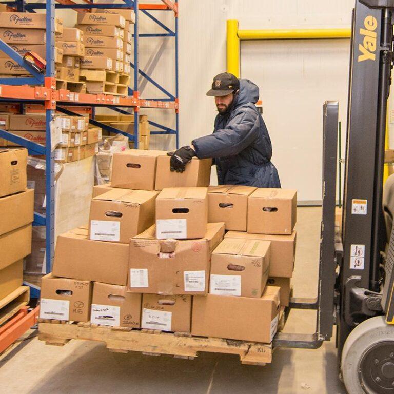 A man loads cardboard boxes