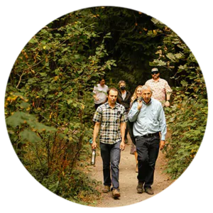 A photo of a small group of people walking through the trees.