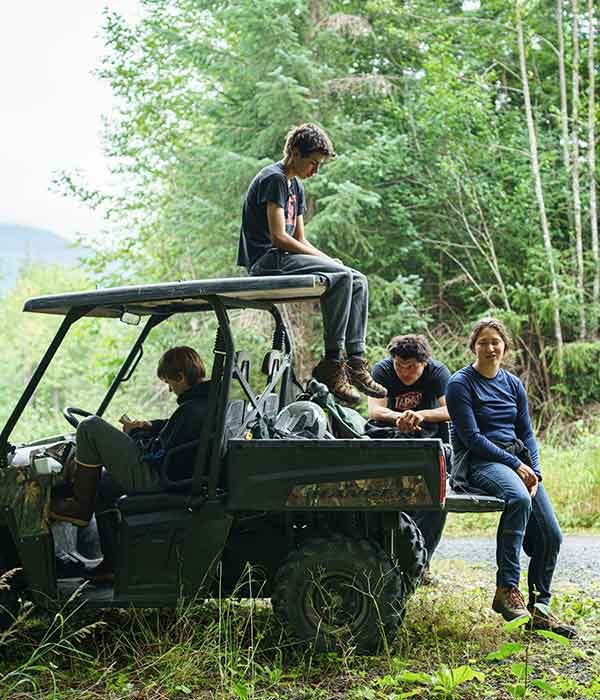 A photo of four people sitting on a off-roading vehicle