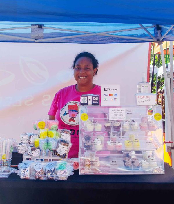 Person standing in front of cupcakes