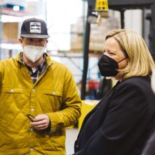 A photo of two people in a warehouse in conversation with each other