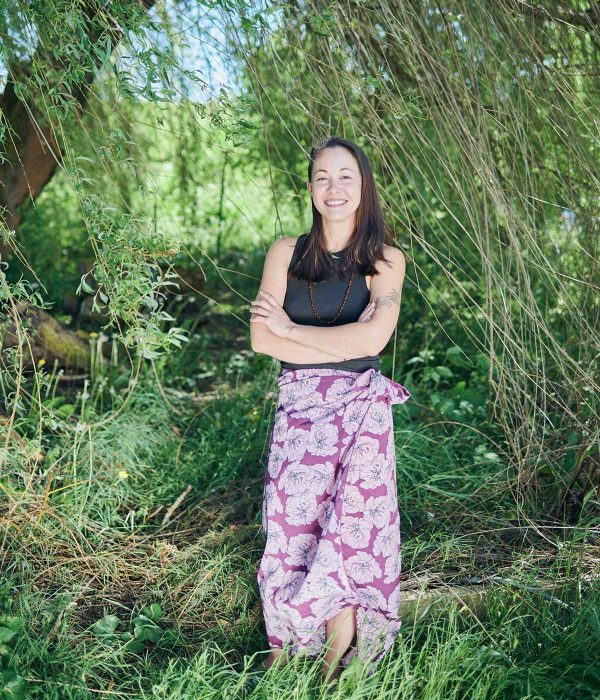 Person smiling at camera outside under a weeping willow tree