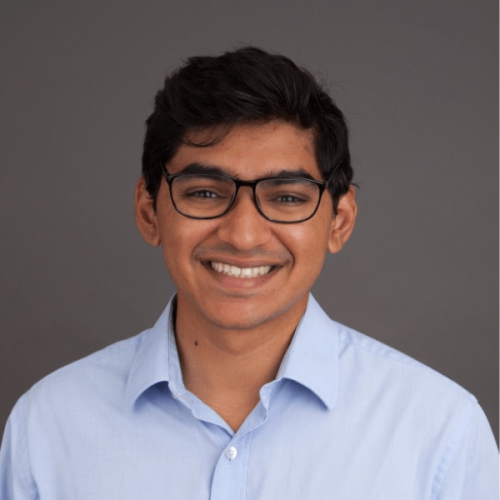 sachin website person with glasses and blue button-up smiling