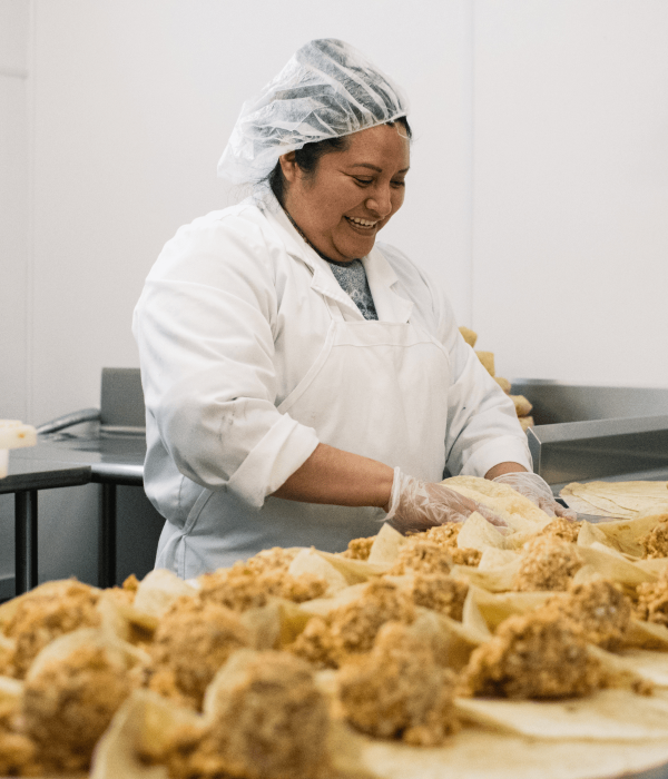 woman in hair net folds burritos