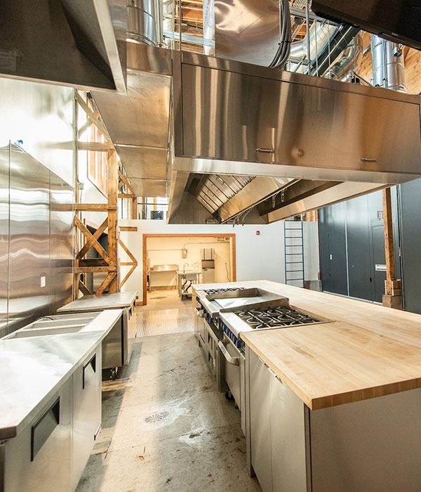 An industrial kitchen space with butcher block countertops and industrial stovetops