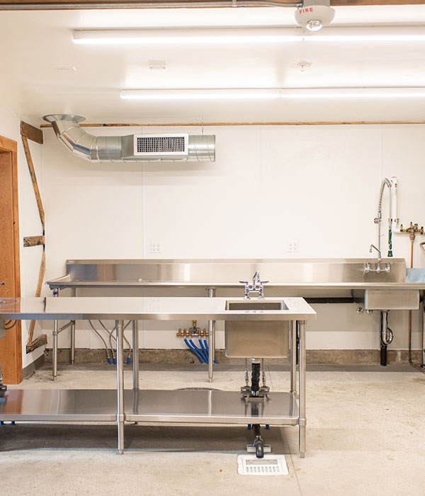 An industrial kitchen space with stainless steel counter tops and large sink